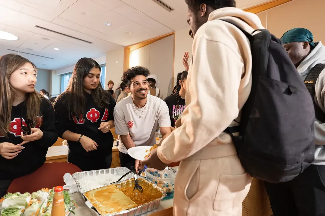 Students getting food from catering trays.